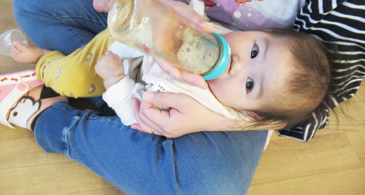 保育園でミルクを飲む赤ちゃんの様子