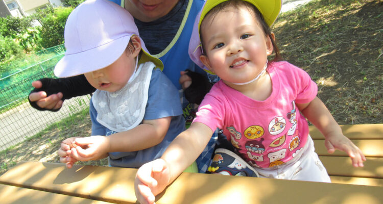 保育園児が公園で先生と遊ぶ様子