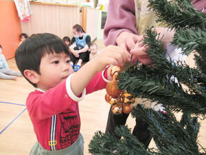 保育園でクリスマスの飾り付けをする園児の様子