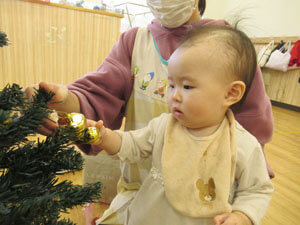 保育園でクリスマスの飾り付けをする園児の様子