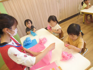 保育園児が先生と七夕の工作をしているところ