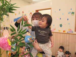 保育園児が七夕の飾りを飾っているところ