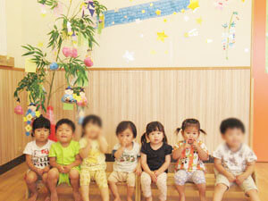 七夕飾りのある教室での保育園の園児たちの集合写真