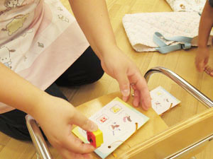 保育園で先生がスタンプを押す様子