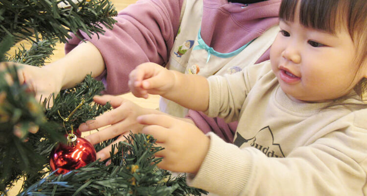 クリスマスの飾り付けをする保育園児