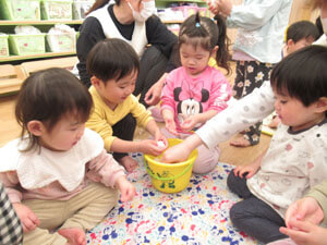 保育園室内で保育園時たちが雪遊を触る様子