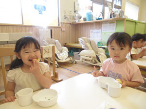 保育園で楽しそうにおやつを食べる園児たちの様子